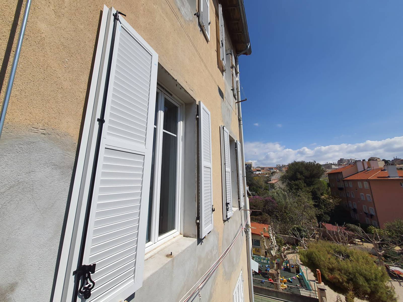 Volets battants en alu blanc RAL 9006 persiennés pour le charme du traditionnel sur Marseille 13007 La Corderie et ses alentours